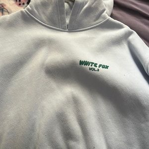 White fox hoodie, light blue with green print.